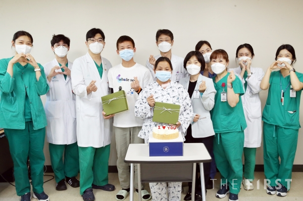 서울아산병원 의료봉사단의 도움으로 한국에서 갑상선암 수술을 받은 야 씨옹 씨가 의료진과 기념사진을 찍고 있다.