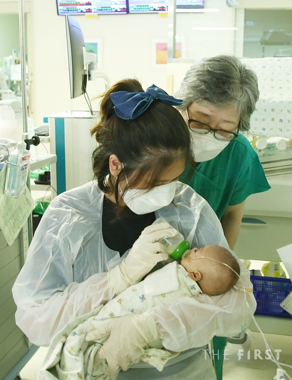 건우의 퇴원을 앞두고 건우 어머니가 주치의 김애란 신생아과 교수의 지도를 받으며 모유를 젖병수유하고 있다.